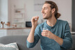 © Pixel-Shot - Handsome young man taking pills at home