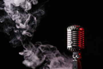 Wall Mural - Retro microphone on dark background with fume