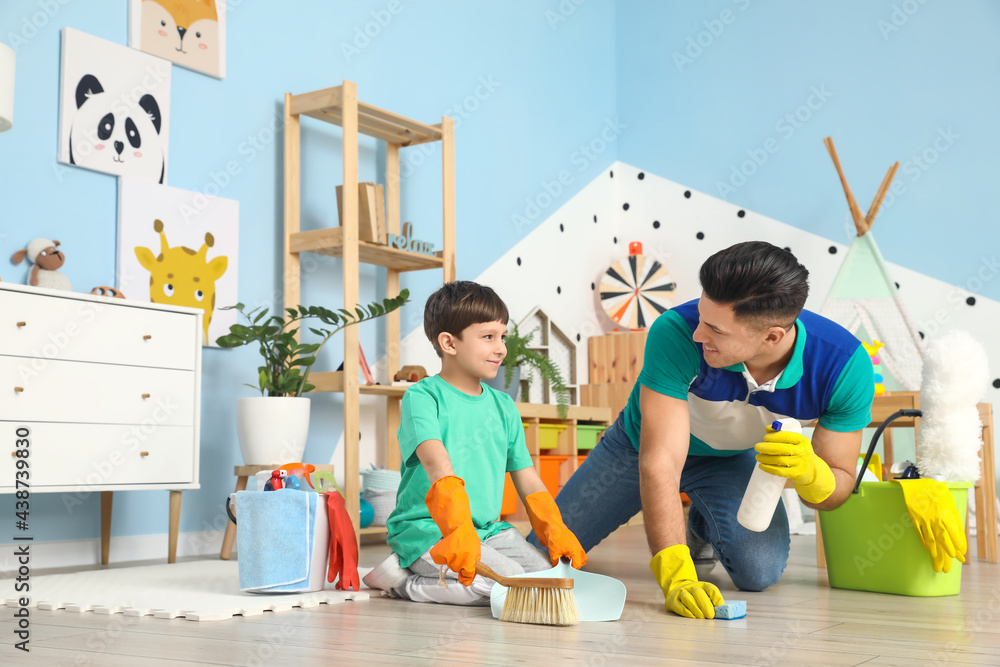 Father and son cleaning floor at home