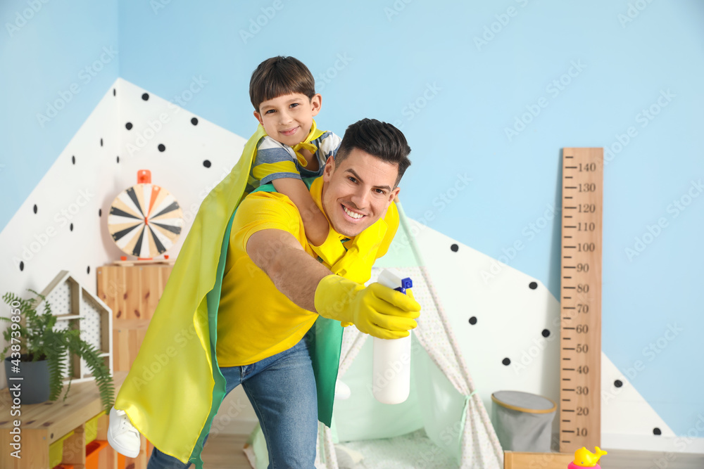 Father and son with cleaning supplies having fun at home
