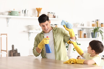 Wall Mural - Father and son having fun while cleaning table in kitchen