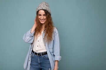 Attractive smiling happy young dark blonde woman standing isolated over colorful background wall wearing everyday stylish outfit showing facial emotions looking at camera