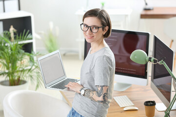Wall Mural - female programmer working with laptop in office
