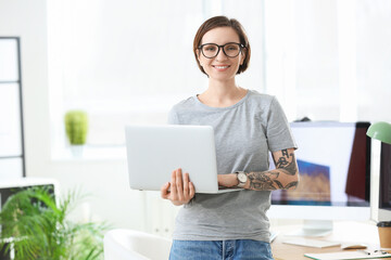 Female programmer working with laptop in office