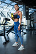 © nazarovsergey - Sporty girl standing in gym, holding water bottle