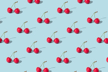 Creative Pattern Made With  Red Cherries On Pastel Blue Background. Summer Or Spring Fruit  Concept. Minimal Aesthetic Idea.
