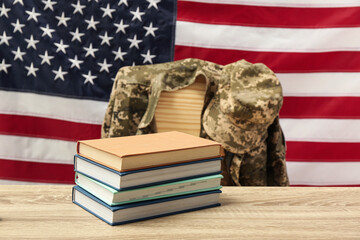 Wall Mural - Books and soldier uniform near flag of United States. Military education