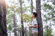Boy praying with holding the Cross in forest with morning light, Focus face, Christian concept.
