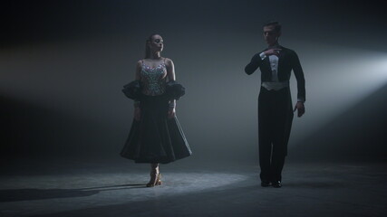 Dance couple bowing after performance. Ballroom dancers standing on stage.