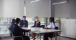 © nimito - International team of business colleagues in protective masks working together in office boardroom