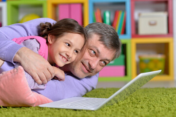 Wall Mural - Father with little daughter using laptop