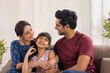 © IndiaPix - A HAPPY FAMILY SITTING AT HOME AND SPENDING TIME WITH EACH OTHER