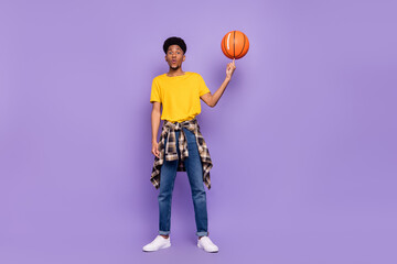 Wall Mural - Full length body size view of attractive funky guy holding spinning ball on fingers having fun isolated over violet purple color background