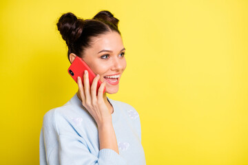 Profile photo of cheerful pretty lady hold telephone look empty space wear blue sweater isolated yellow background