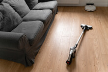 Cleaning Wooden Floor With Wireless Vacuum Cleaner. Handheld Cordless Cleaner. Household Appliance. Housework Modern Equipment