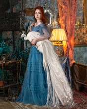 Girl In A Blue Dress With A White Peacock In Her Arms