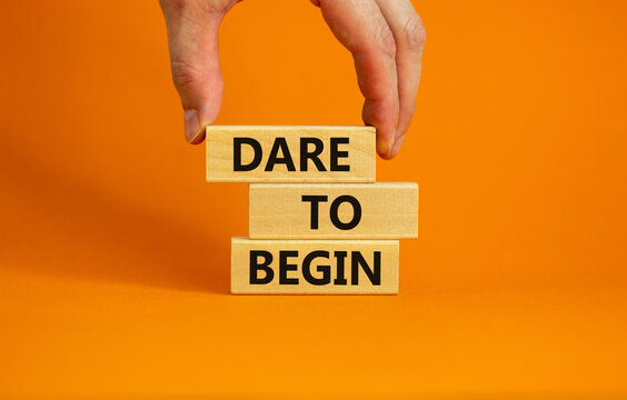 dare to begin symbol. wooden blocks with words 'dare to begin'. beautiful orange background, busines