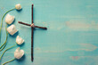 Christian cross with white flowers on blue wood background