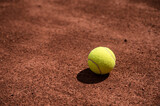Fototapeta  - Close-up of yellow tennis ball on clay tennis court. Sport. Lifestyle.