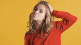Fototapeta Tęcza - Beautiful teenager girl dressed in red sweater sending air kiss