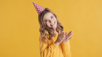 Wall Mural - Beautiful excited teenager girl wearing birthday hat looking che