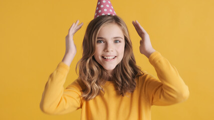 Wall Mural - Cheerful teenage girl in party hat happily posing on camera cele