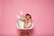 © Татьяна Добрикова - Cute little girl sitting on the white chair on a pink background. Space for text.