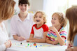 © famveldman - Family playing board game. Kids play.