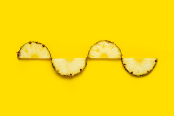 Wall Mural - Pineapple slice against on a yellow background. Top view, flat lay