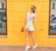 Fashion outdoor image of stylish young hipster blonde woman wearing mini floral dress