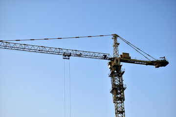 Yellow tower crane its boom is a building under construction