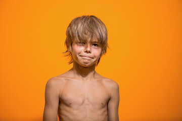 portrait of a cute little boy over bright orange background