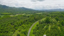 Aerial View Of Thai Local Old Classic Train On Railway With Green Mountain Hills And Forest Trees, Thailand In Public Transportation Concept.