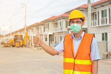 Foreman, an Asian man wearing the mask, thumbs up, visits house construction to be successful in the concept of construction, engineering