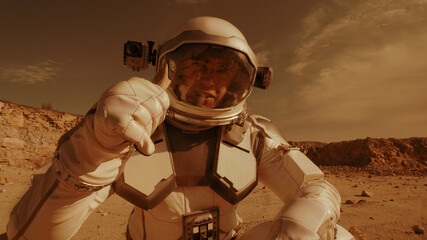 Wall Mural - Male astronaut recording video on Mars