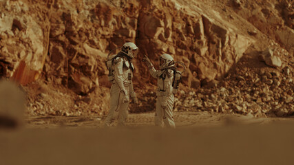 Wall Mural - Male and female cosmonauts walking on Mars