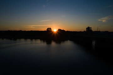 Summer sunset on the riverbank. City bridges over the river