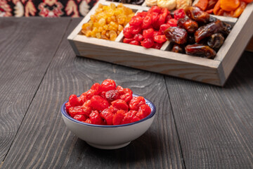 Wall Mural - dried cherries in a bowl on a wooden table