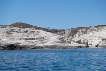 Wall Mural - Sarakiniko beach at Milos island, Cyclades Greece. White rock formations, cliffs and caves over blue sea