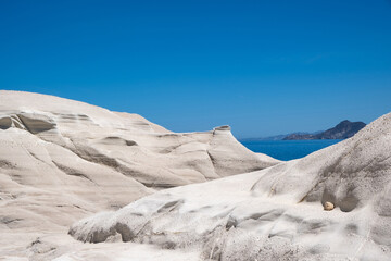 Wall Mural - Lunar landscape at Sarakiniko beach, Milos island, Cyclades Greece, Abstract natural rock shapes. White stone formation, blue sky backgroynd.