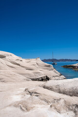 Wall Mural - Sarakiniko beach at Milos island, Cyclades Greece. White rock formations, cliffs and caves over blue sea