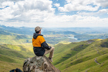 Young Man Enjoying Scenery View Of Green Valley During The Hike To Drakensberg Mountains