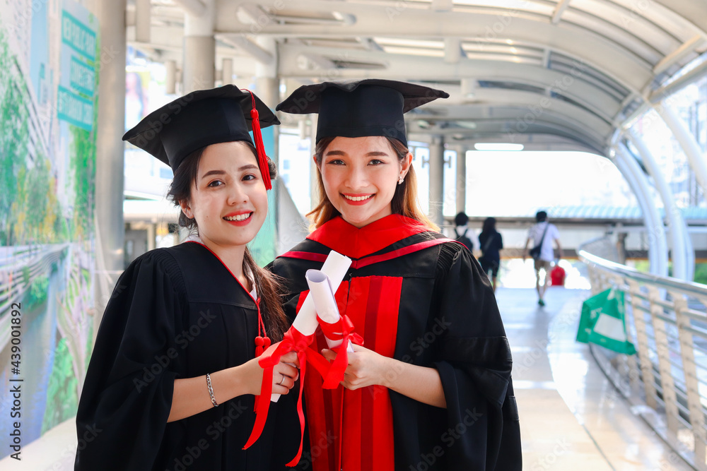 Portrait of two happy smiling graduated students holding certificate ...