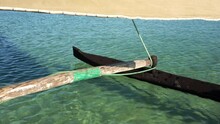 Looking To Wooden Pole And Board Of Pirogue - Typical Madagascar Small Fishing Boat - Sailing Over Clear Green Sea Water