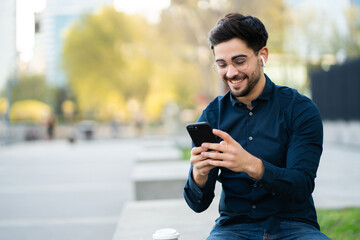 young man using his mobile phone outdoors.