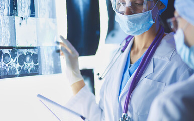 Wall Mural - Two female women medical doctors looking at x-rays in a hospital.