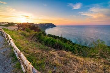 Sunset landscape Conero natural park dramatic coast headland rocky cliff adriatic sea beautiful sky colorful horizon, tourism destination Italy