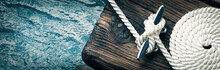 Close-up Of Coiled Boat Rope Secured To Cleat On Wooden Dock 