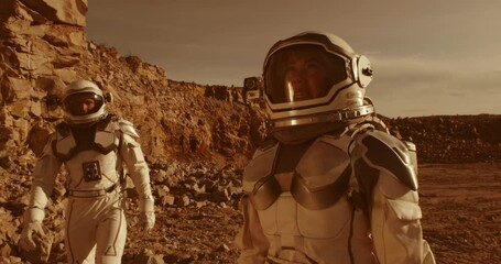 Wall Mural - Male astronaut adjusting camera on colleague