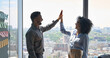 © insta_photos - Happy cheerful successful business partners indian businessman and African American businesswoman giving high five celebrating project victory standing in office near urban view panoramic window.